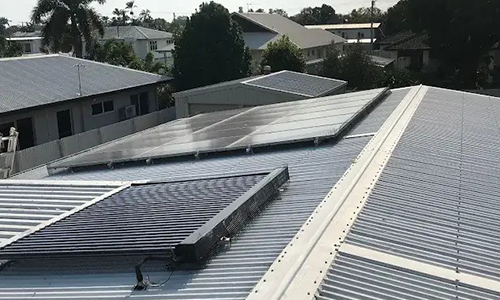 Solar panels on a grey corrugated metal house roof